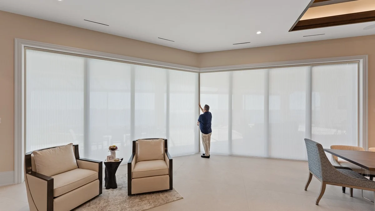 Wide light-filtering shades controlling glare in a Boca Grande waterfront living area