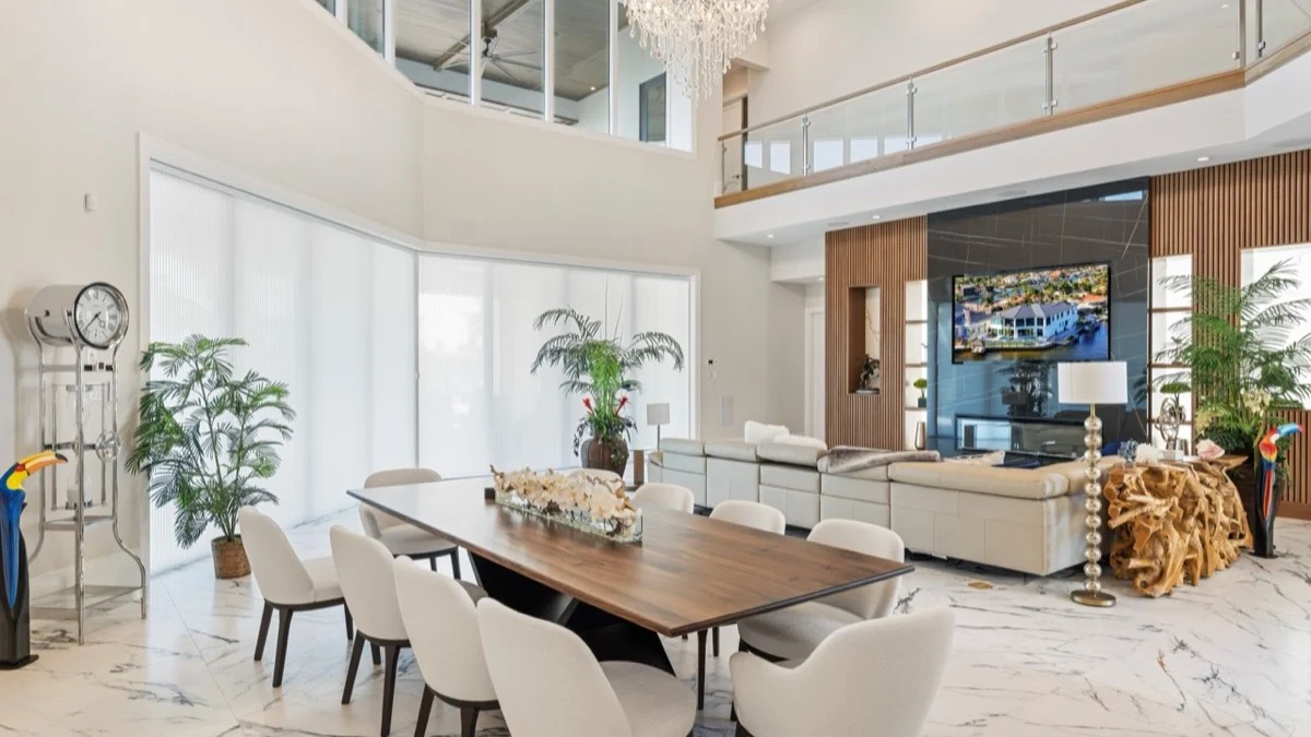 Energy-efficient honeycomb shades covering oversized sliders beside a dining and living area