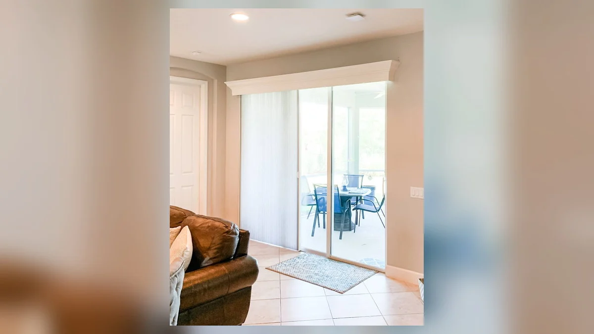 Vertical blinds stacked beside a wide sliding glass door