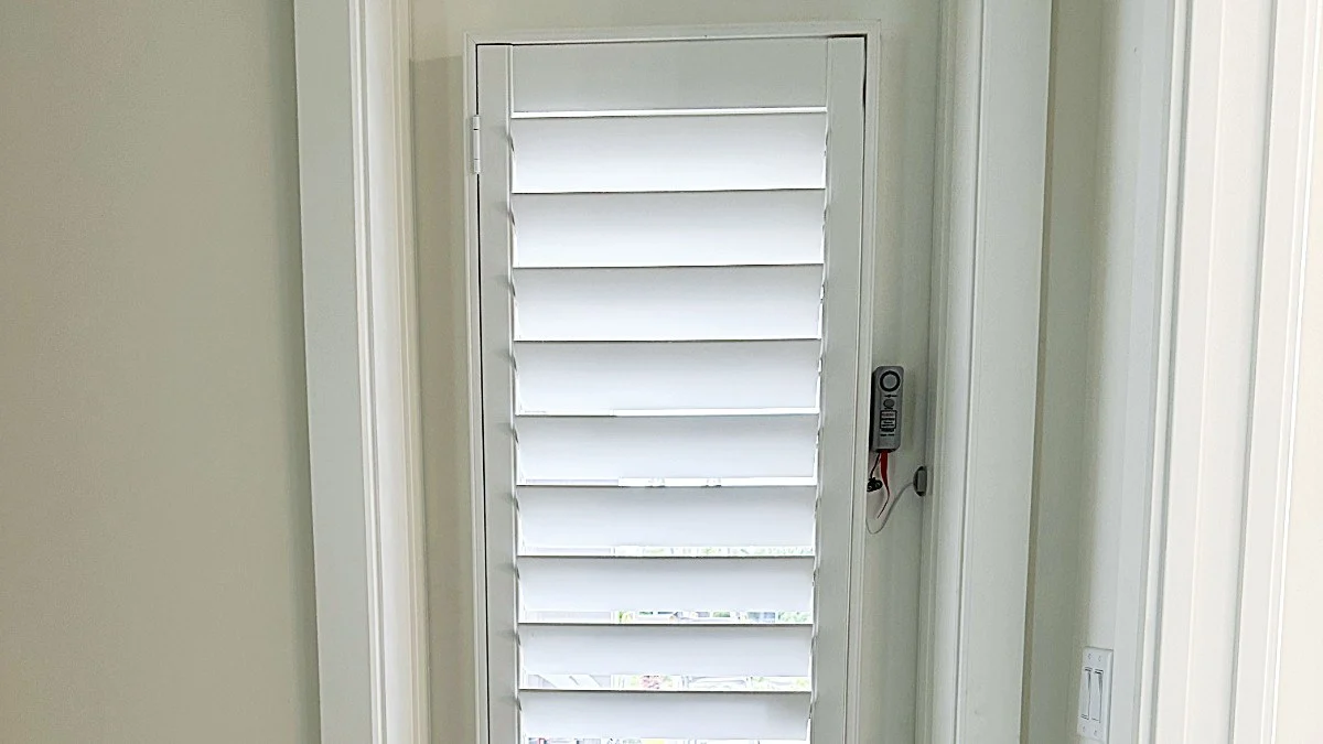 Door-mounted window treatment secured for everyday operation