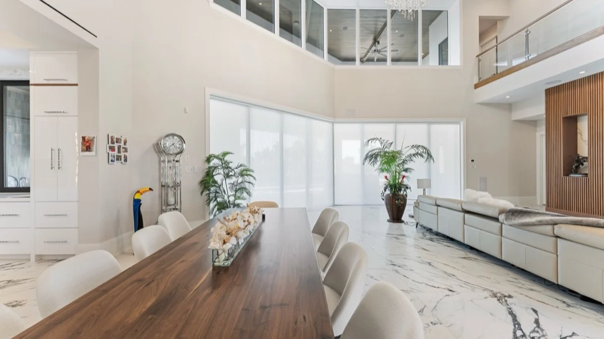 Honeycomb shades covering oversized sliding glass doors beside a dining room