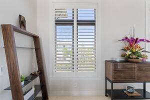 Plantation-style sliding shutter blinds on tall windows, offering adjustable light control and privacy.