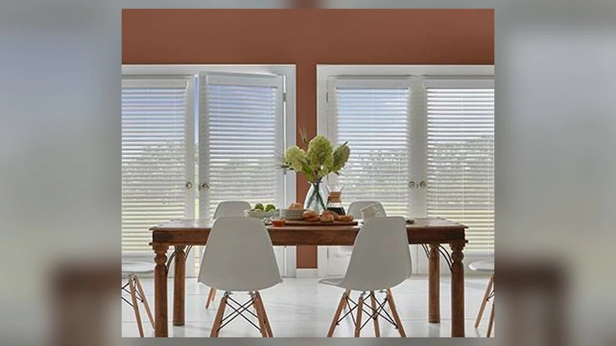 Faux wood horizontal blinds filtering light in a dining room