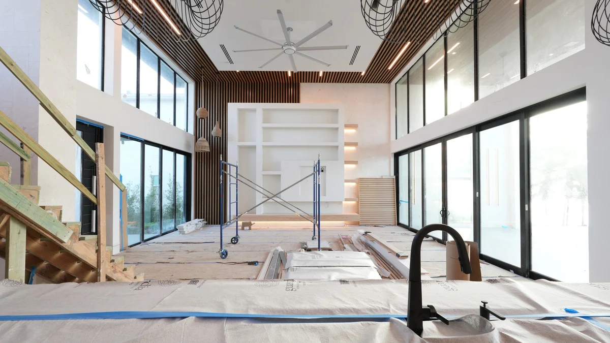 Uncovered floor-to-ceiling windows and scaffolding in a double-height great room