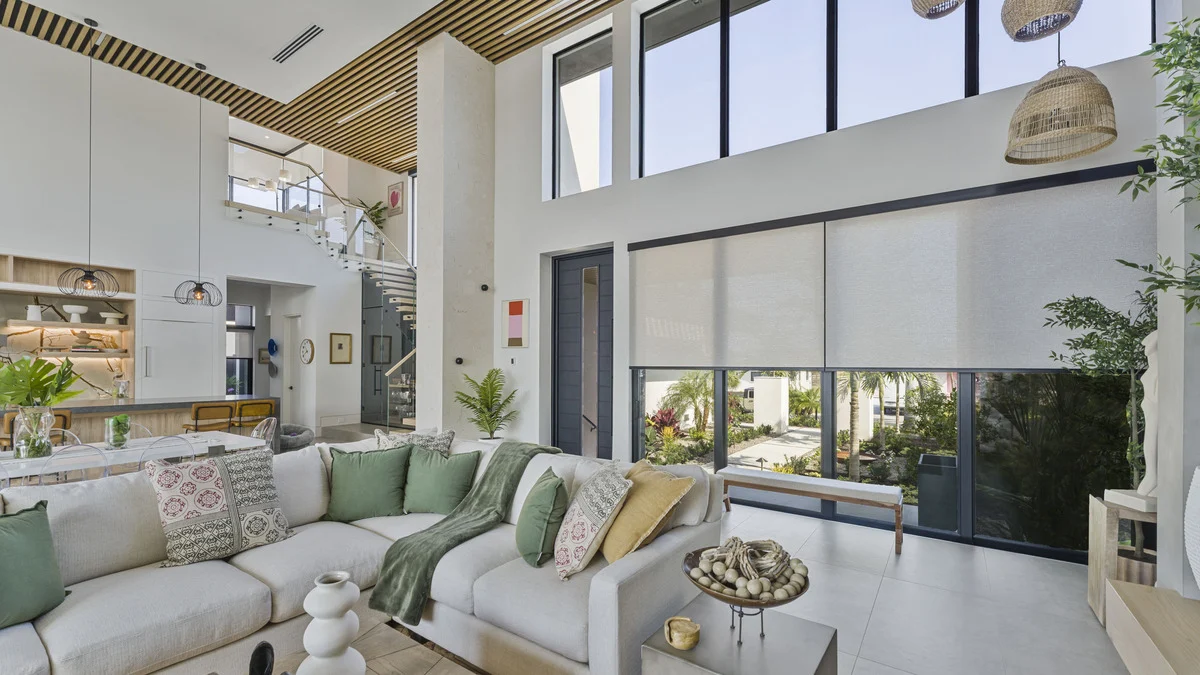 Partially lowered roller shades above sliding glass doors beside the furnished living area