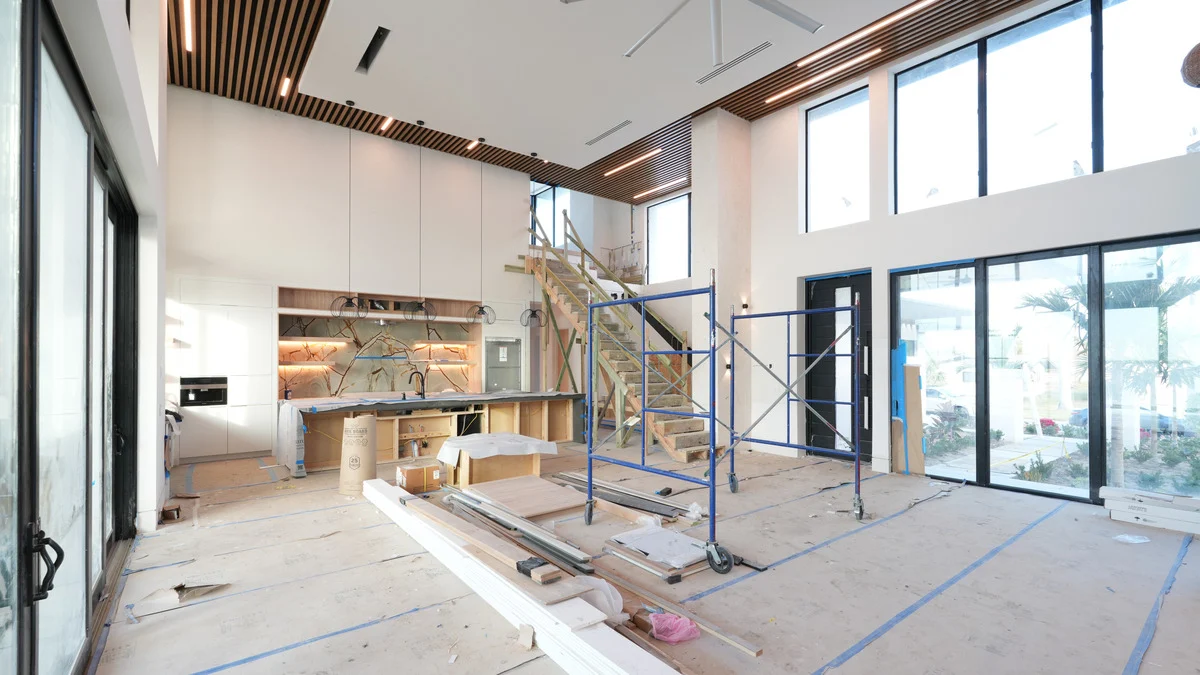 Uncovered sliding glass doors beside the unfinished kitchen and bar in the great room