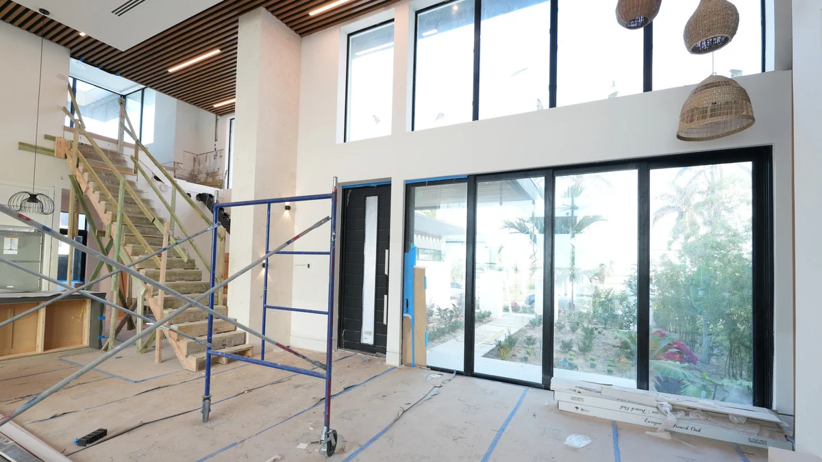 Uncovered great-room sliding doors beneath a row of high transom windows
