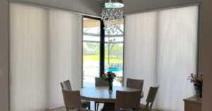 Light-colored window treatments surrounding a dining table