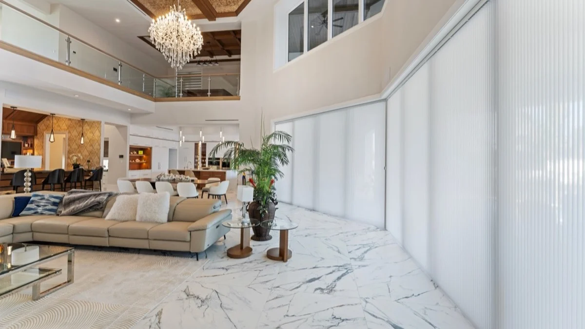 Vertical honeycomb shades extended across wide sliding glass doors in an open-concept living room