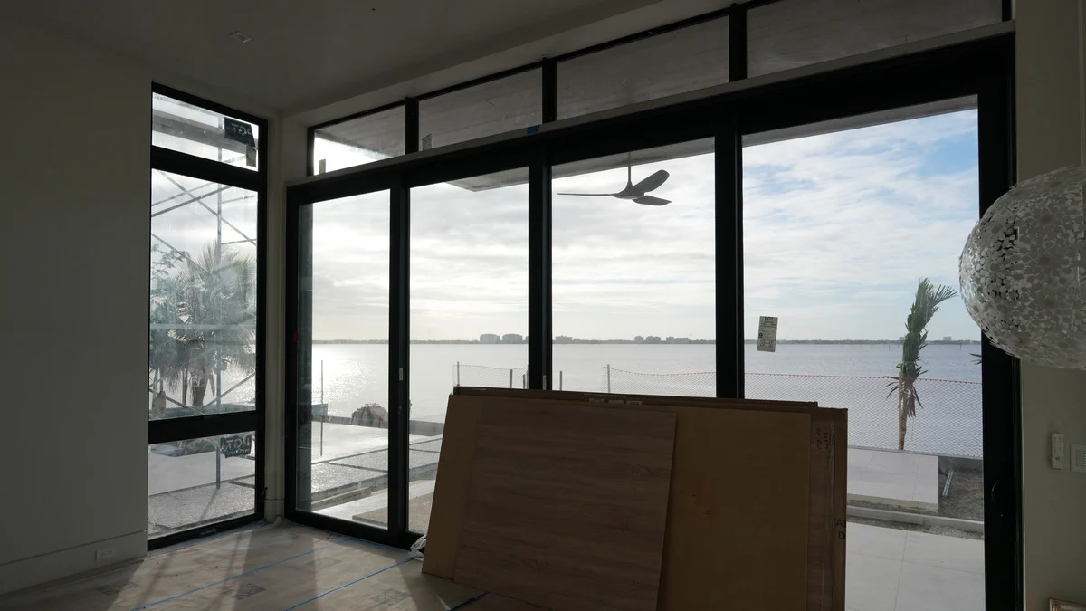 Uncovered corner glass doors and transoms overlooking the water during bedroom construction