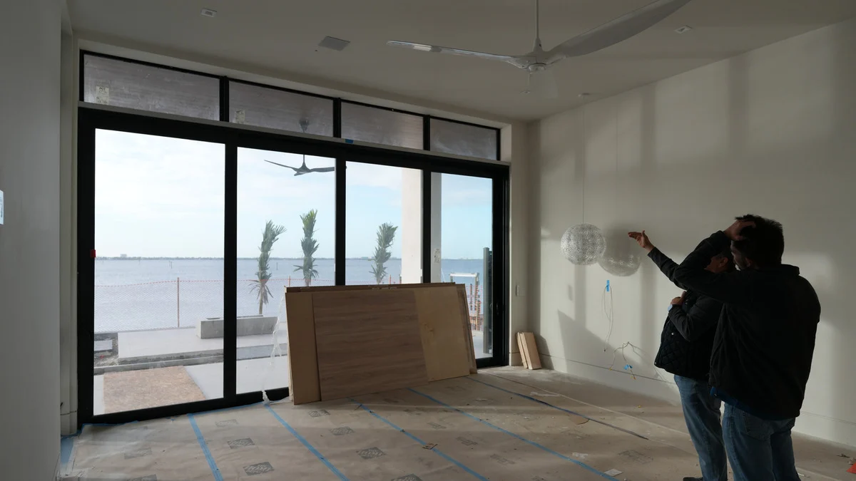 Uncovered sliding doors and transom windows in a bedroom under construction